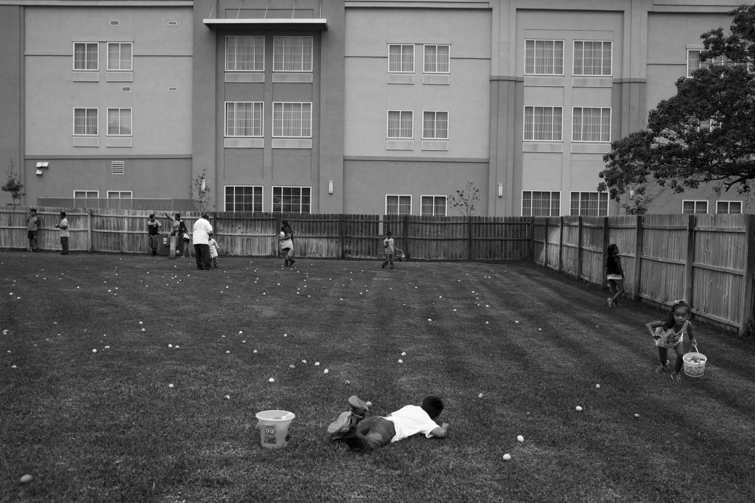 The LaQuinta Inn and Suites looms over the backyard as children go on an Easter egg hunt at Jessie Galindo's house in Cotulla, Texas on April 5, 2015. Her husband, father, uncle and other members of her family all work in the oil field. "Jessie hates having the hotels around her house because now any random stranger can watch her and her kids play in the yard. There is no privacy in this town anymore," Galindo's sister JoAnna Gonzalez said. Towns like Cotulla that experienced great growth in the oil boom did not have zoning policies in place to deal with that growth. 