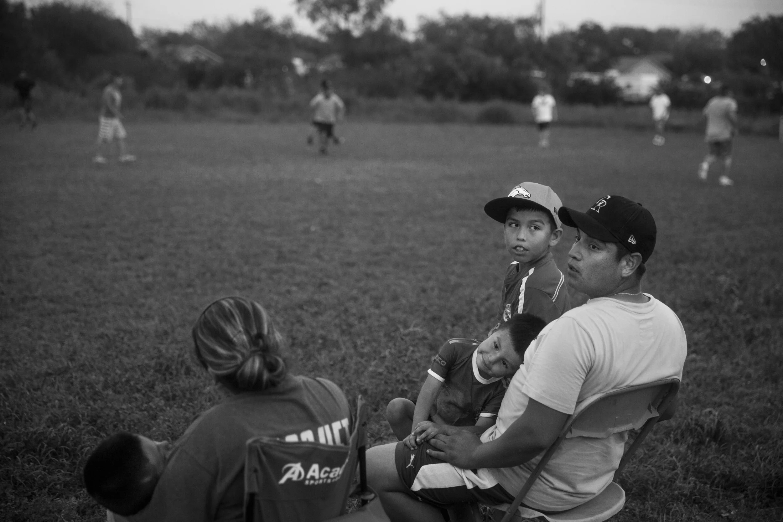 Isaac Rodriguez, 10, looks back at his dad Eduardo Rodriguez as his brother Noe Rodriguez, 3, looks at his mom Jessica Rodriguez during a soccer match between Eduardo Rodriguez's friends from the oil field and El Charro Mexican Restaurant employees at the Cotulla RV Park in Cotulla, Texas on April 7, 2015. The restaurant employees won 3-0 in their weekly soccer match, which ended when the oil field group moved to Dilley, Texas for work.