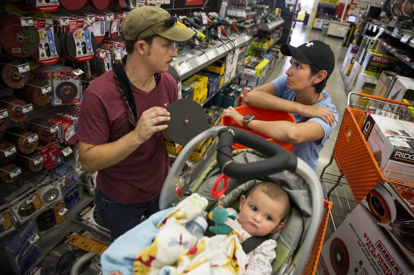  Jarrell Bamberger talks to his wife Glenda Bamberger about what they need to start building their home while their daughter Esmebella, 9 months, sits in their shopping cart at Home Depot in Bulverde, Texas on July 10, 2015. They began construction o