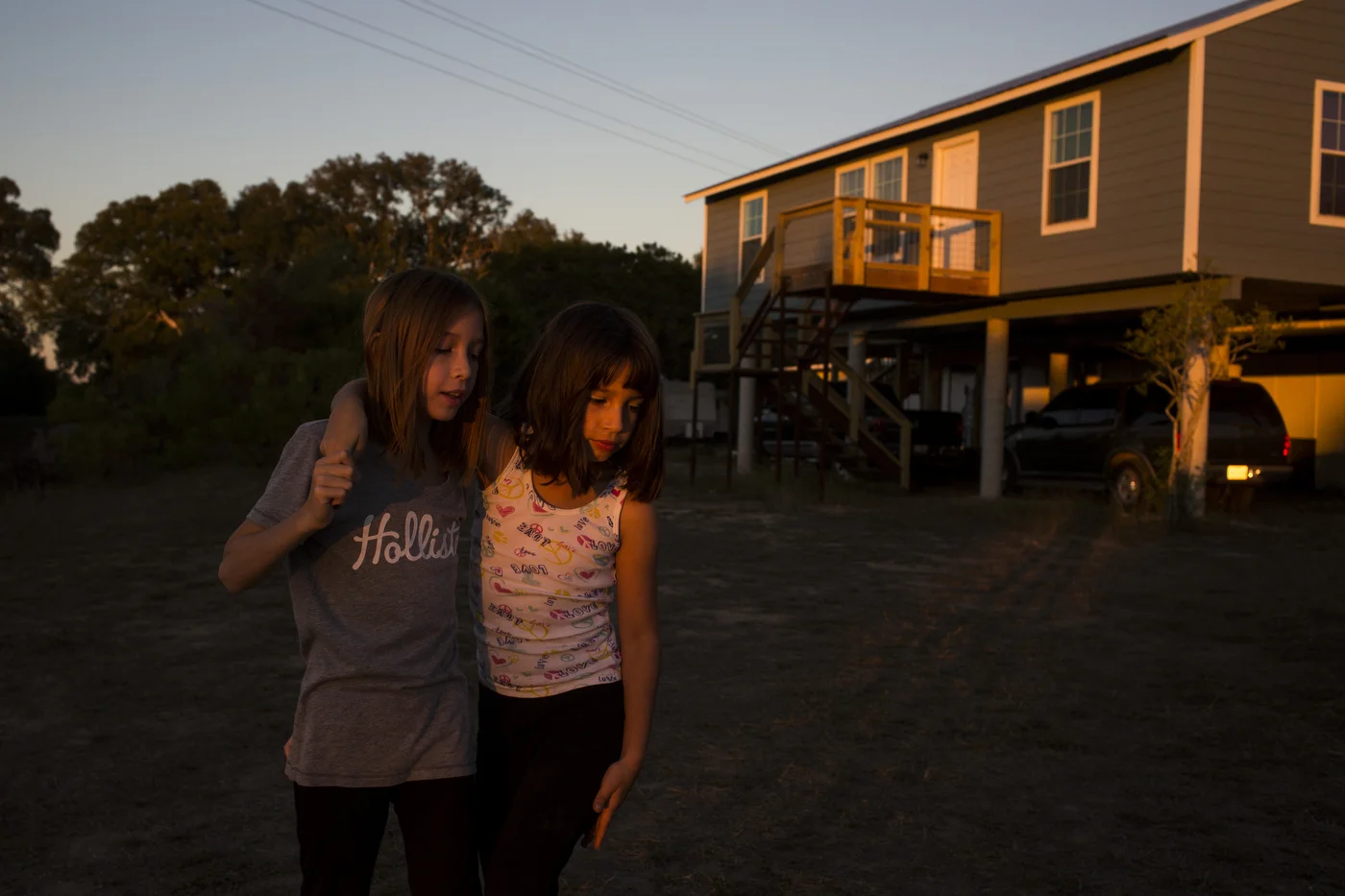  Serenity Bamberger, right, leans on her sister Cielo Bamberger outside of their new house in Blanco, Texas, U.S. on October 27, 2015.  This was the first night that they began living in their new home since its completion.  Three days later, the sam