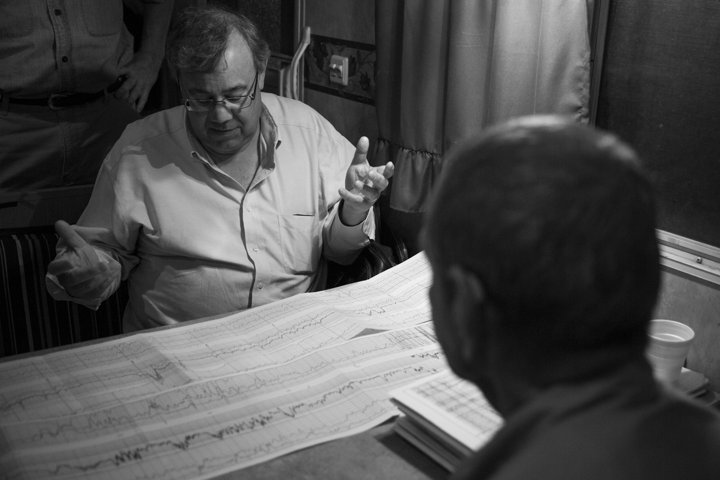  Harvey Howell, center, looks at data from the mud log
with Hans Helland, right, and Frank Sitterle, left, in a trailer on an oil rig site in Hallettsville, Texas, U.S. on May 22, 2015.  The mud log data shows how much crude oil exists at various dep