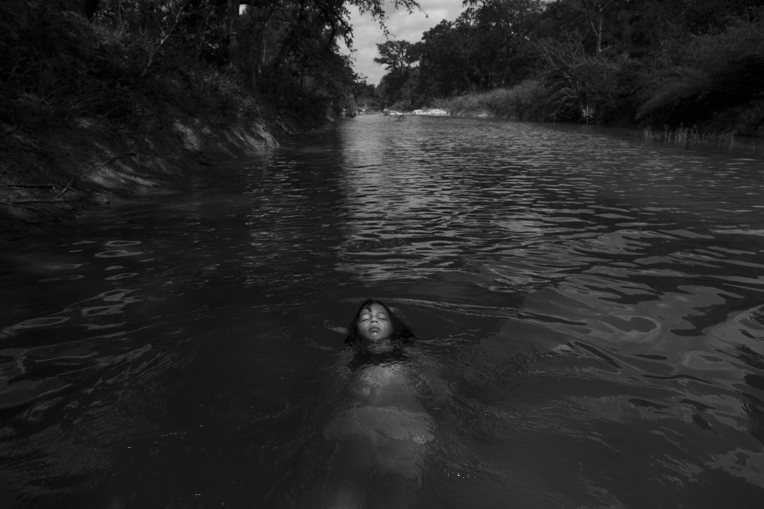  Serenity Bamberger floats in the Little Blanco River along her family's property on August 18, 2015 in Blanco, Texas. Three months prior, over Memorial Day, the same river flooded their home and business destroying the majority of the family's belon