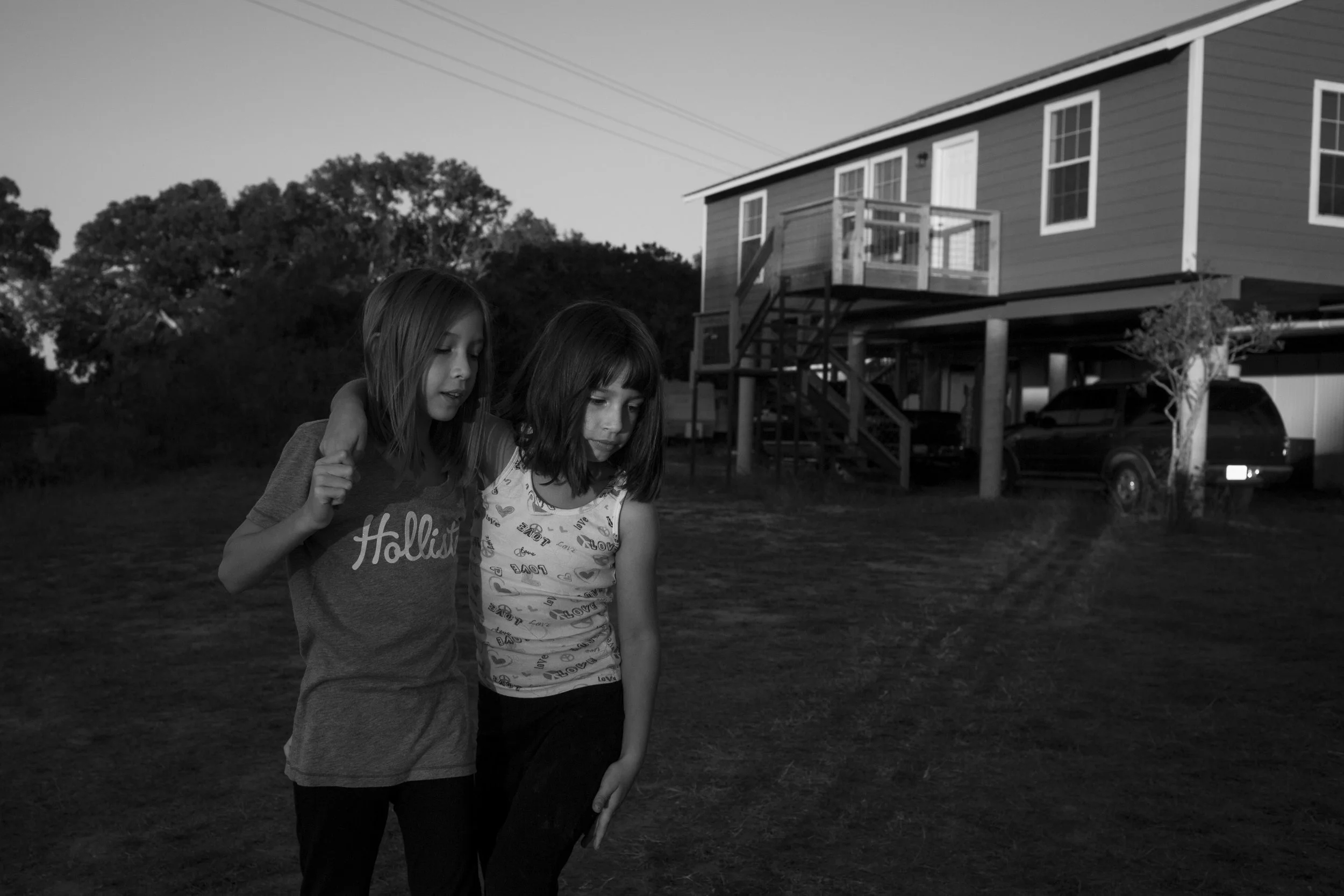  Serenity Bamberger, right, leans on her sister Cielo Bamberger outside of their new house in Blanco, Texas, U.S. on October 27, 2015. This was the first night that they slept in their new home since its completion. Three days later, the same river t
