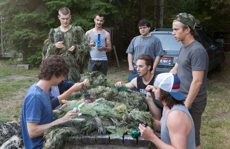Jonathan Daniel Brown (center, with glasses) plays real-life pot smuggler Nate Norman in Kid Cannabis.