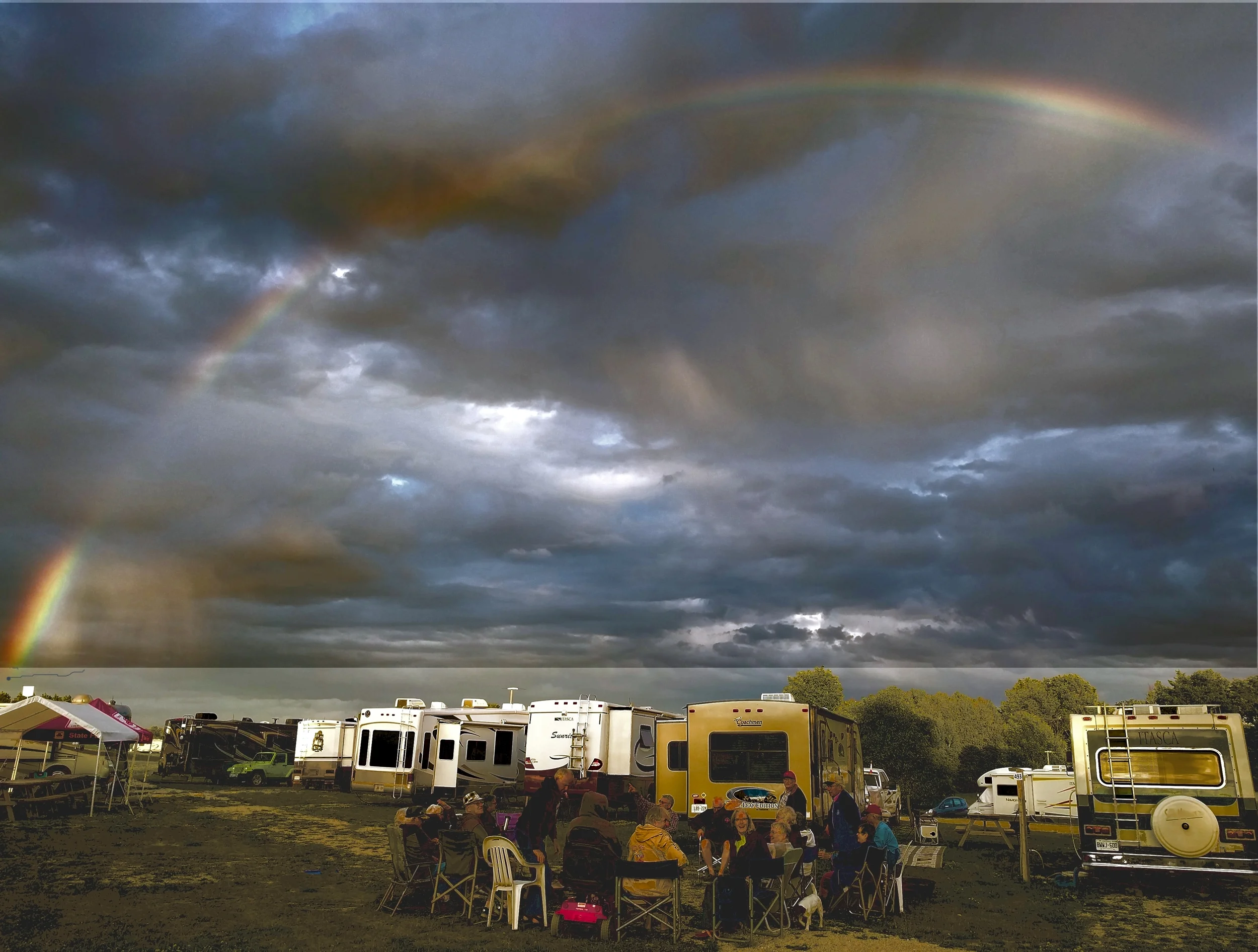 A rainbow hovers above as the group gathers around a warm fire.
