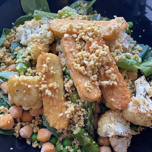 Salad with roasted cauliflower and asparagus, tempeh strips, and cashew vegan parm