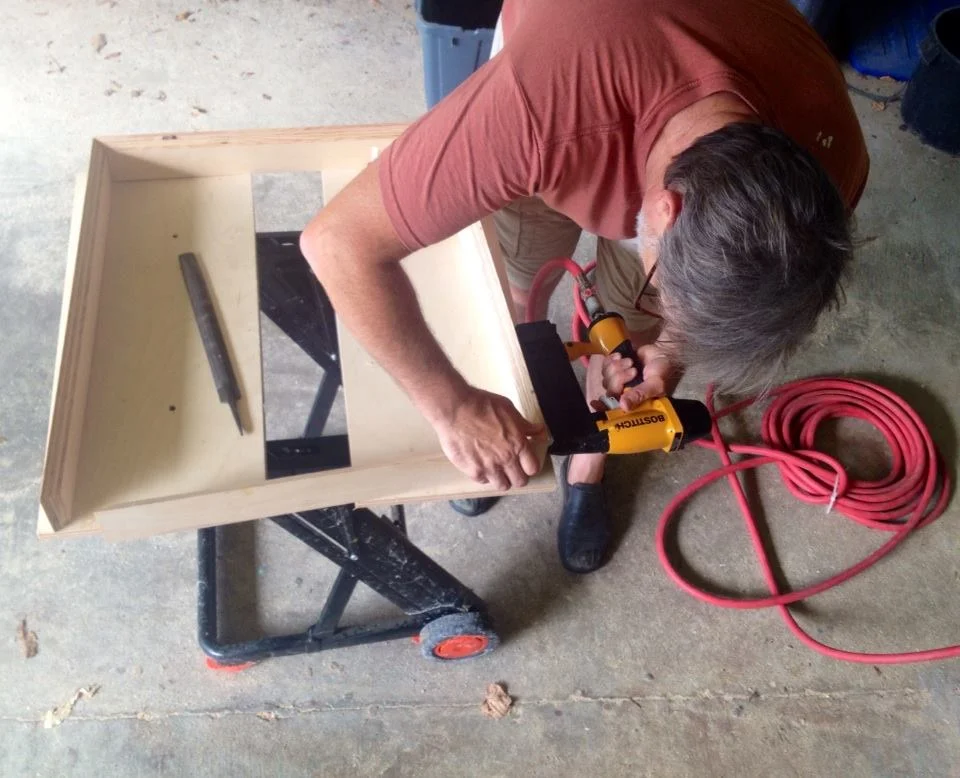 Scott is building Dori's frames for the upcoming DECADE 10th Anniversary exhibit at Red Dot. He loves his outdoor wood shop in the Alabama summer heat.
