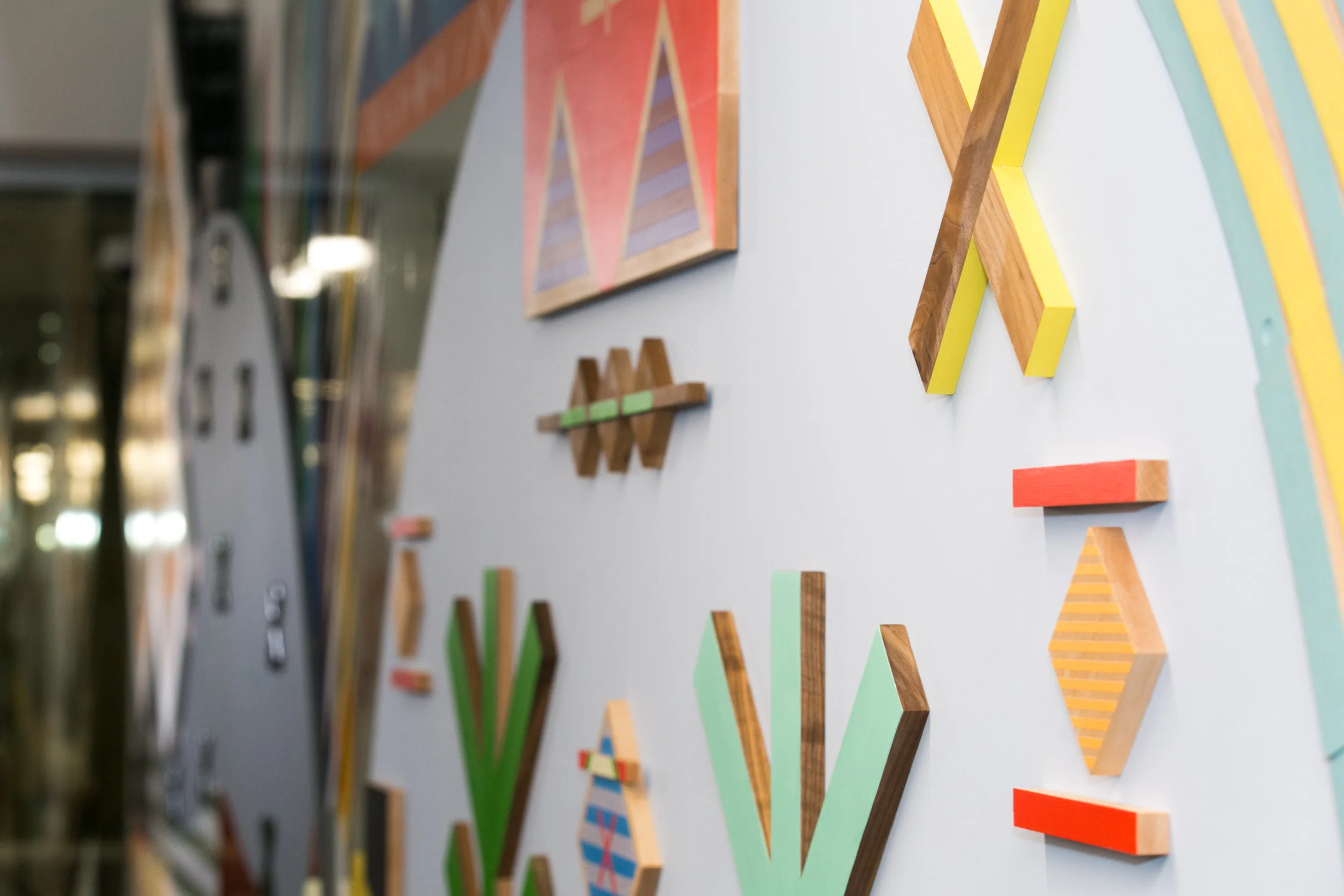 Pjila'si, 2019 Zatzman Sportsplex , Dartmouth Materials: Oak, walnut, maple, Labradorite, steel, acrylic paint, ash, plexiglass, 3M reflective print on Aluminum panels Dimensions: 35’x10’x2’ Photo: Chantal Routhier Installation commissioned by City of Halifax Regional Municipality Project managed by IOTA STUDIOS