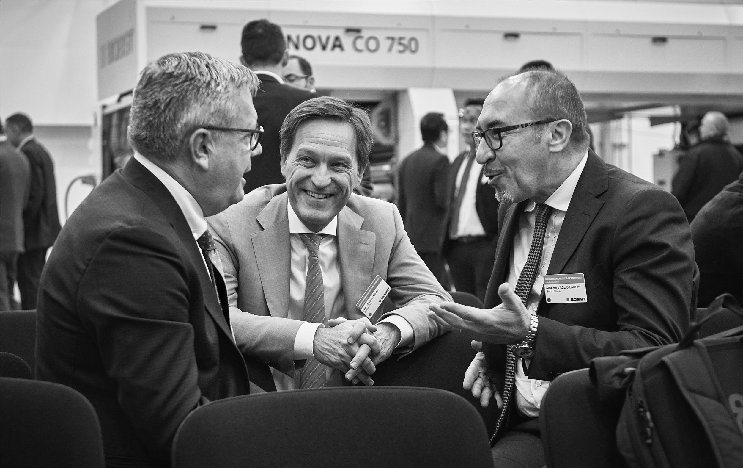 Candid photograph of three businessmen in a meeting smiling