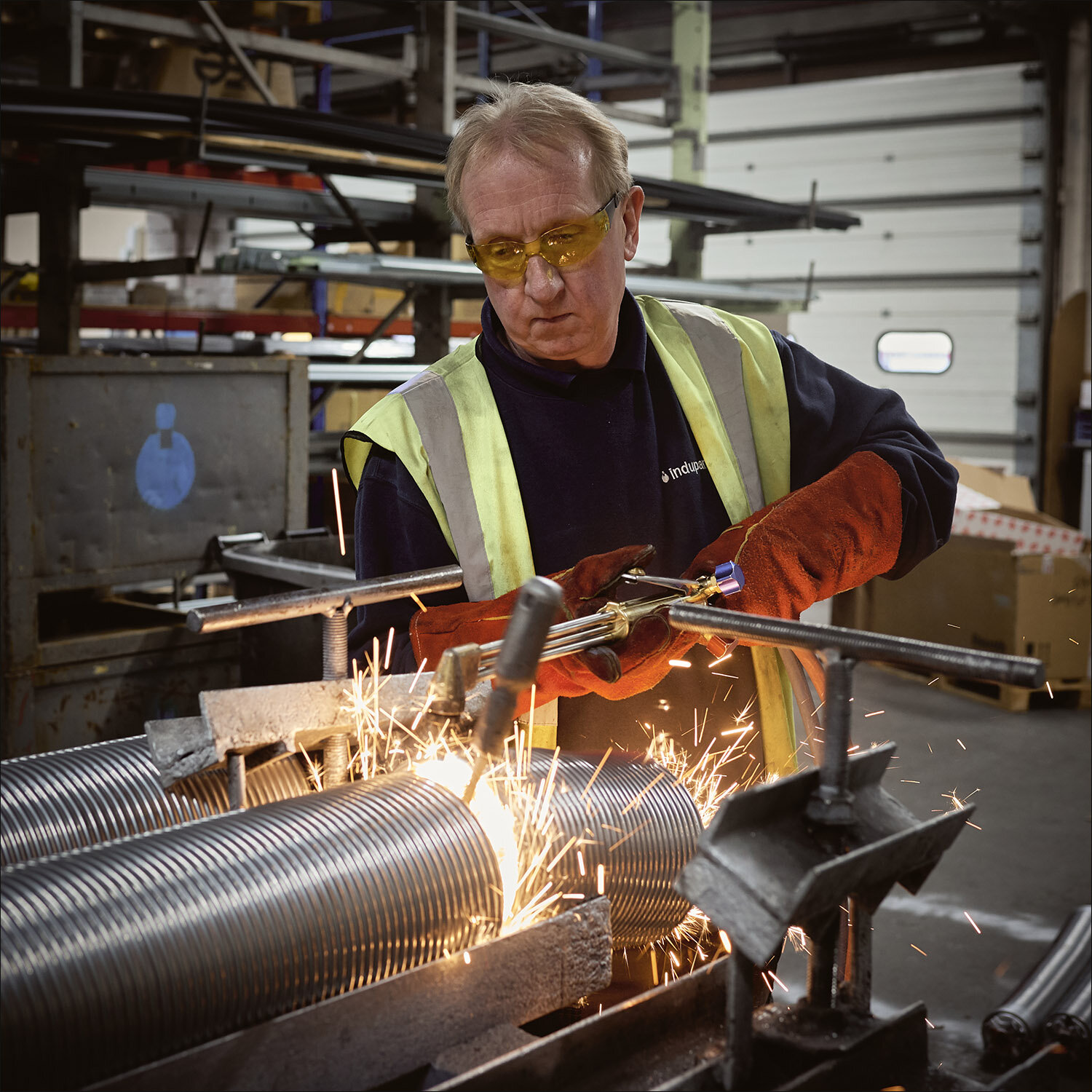 man cutting steel springs in a factory