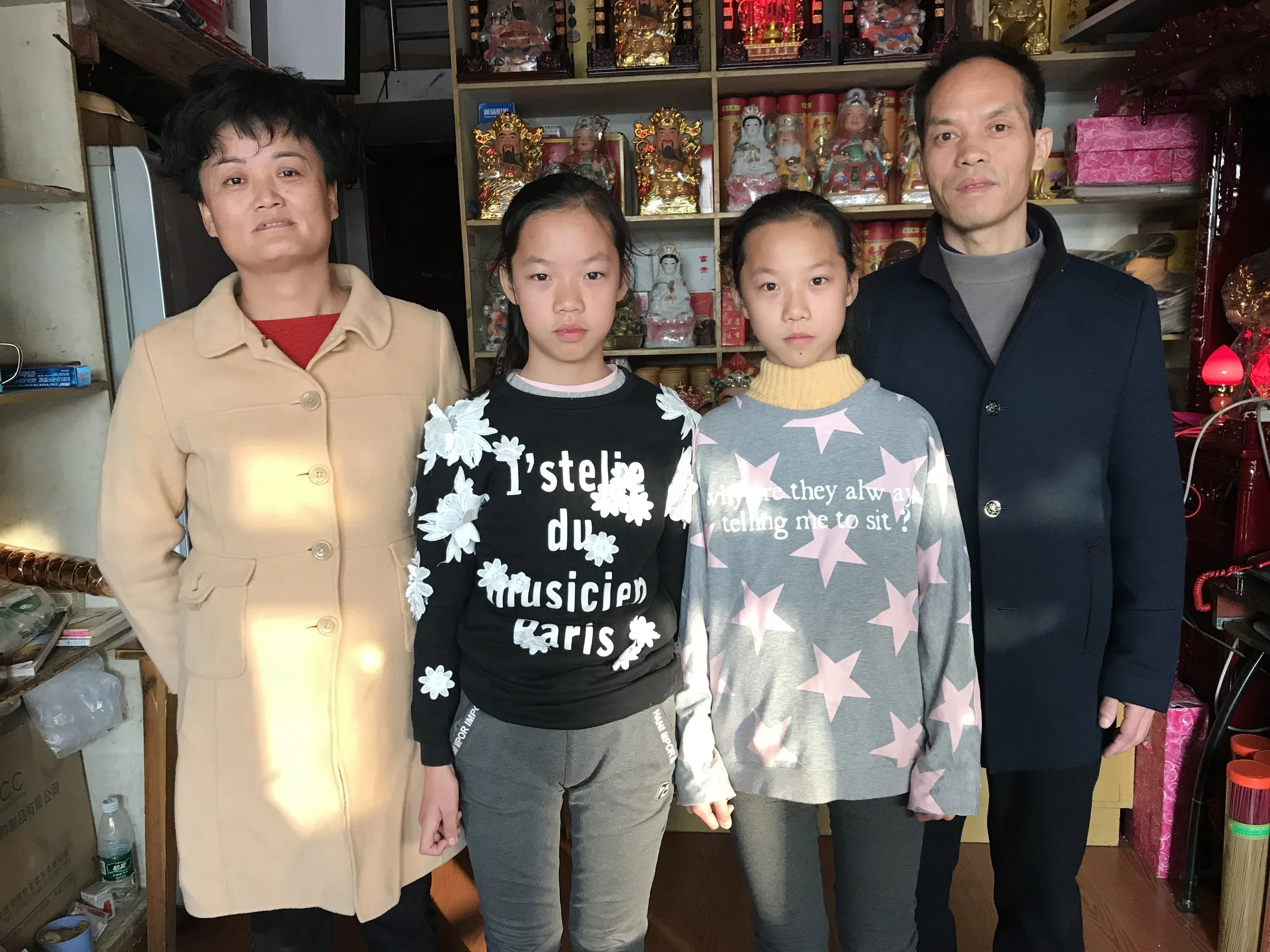 Mother, Zhu Yuan e, and father Xin Xian Shou, with their daughters inside the incense shop, 2017.