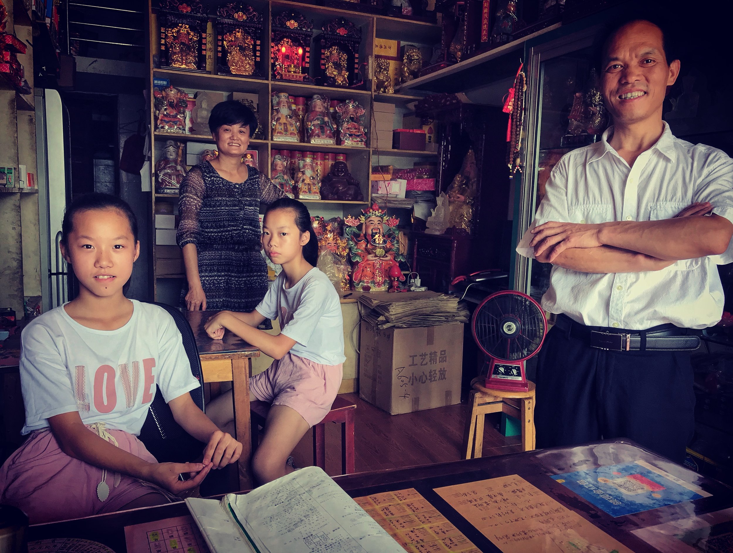  Mother, Zhu Yuan e, and father Xin Xian Shou, with their daughters inside the incense shop, 2018. 