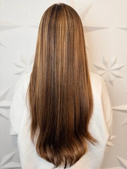 Long brunette hair with subtle caramel highlights and a sleek, blended finish, created by Stormi at Chroma Salon Queen Anne Seattle for natural dimension.