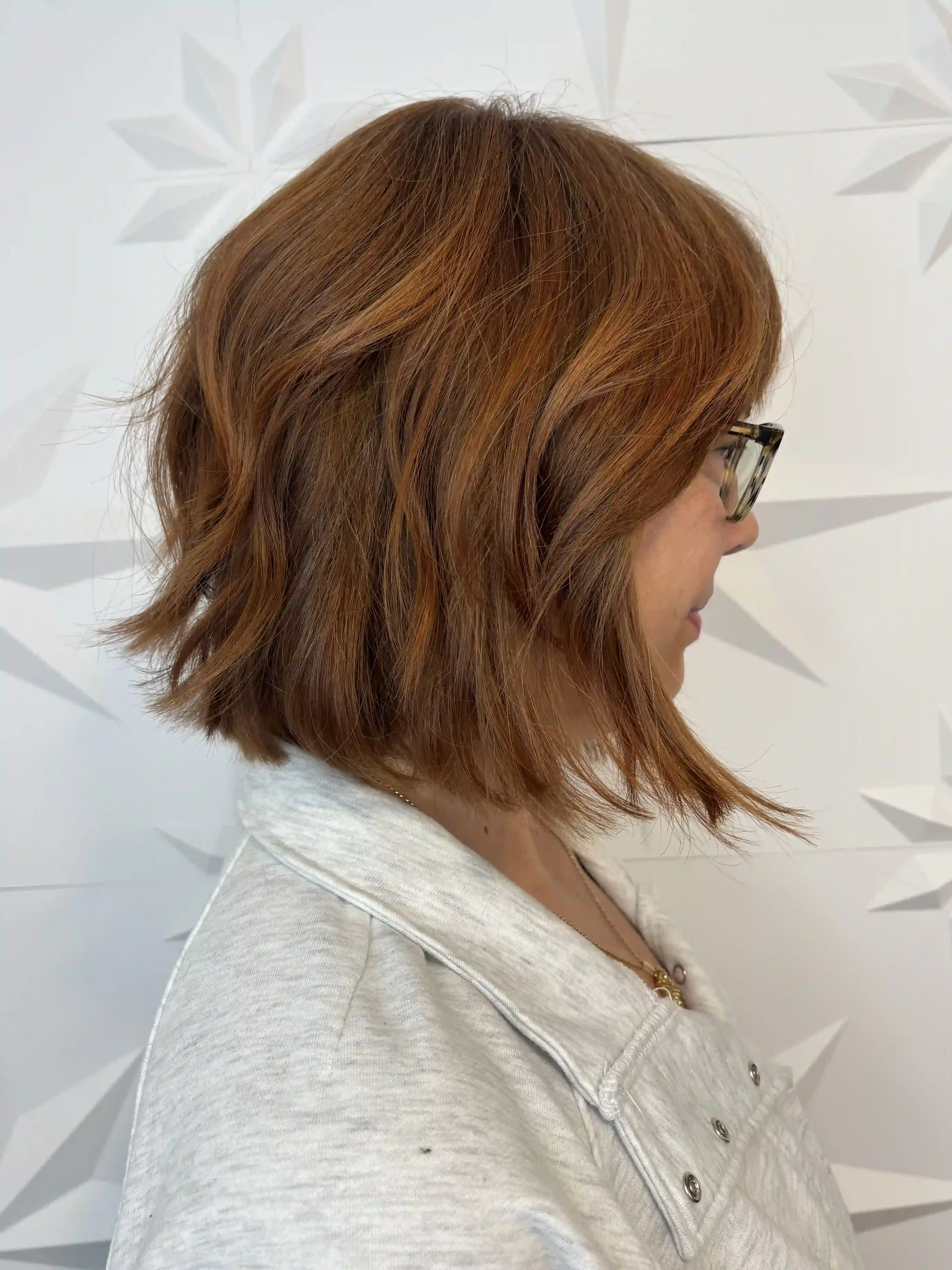 Textured copper bob featuring rich cinnamon and copper tones with soft dimensional depth. This modern jaw-length haircut combines lived-in texture, airy movement, and face-framing layers for an effortless, versatile finish that enhances shine and nat