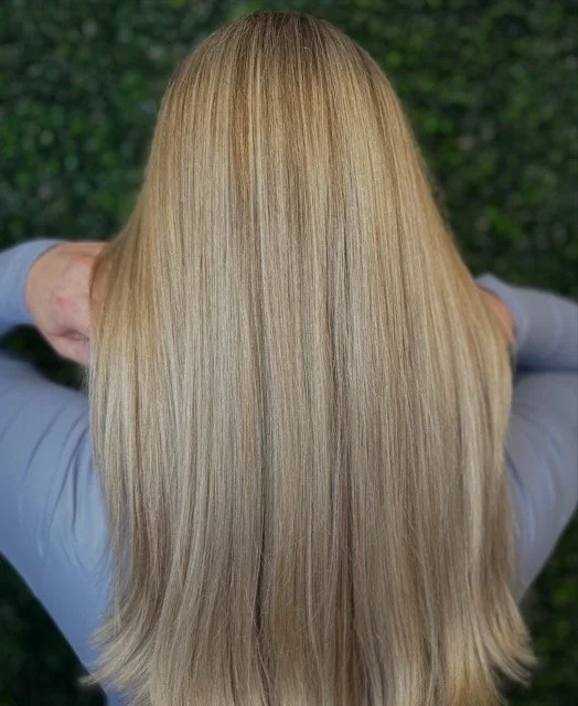 Smooth beige blonde hair with long layers and a seamless blend, created by Stormi at Chroma Salon Queen Anne Seattle for soft, natural dimension and shine.