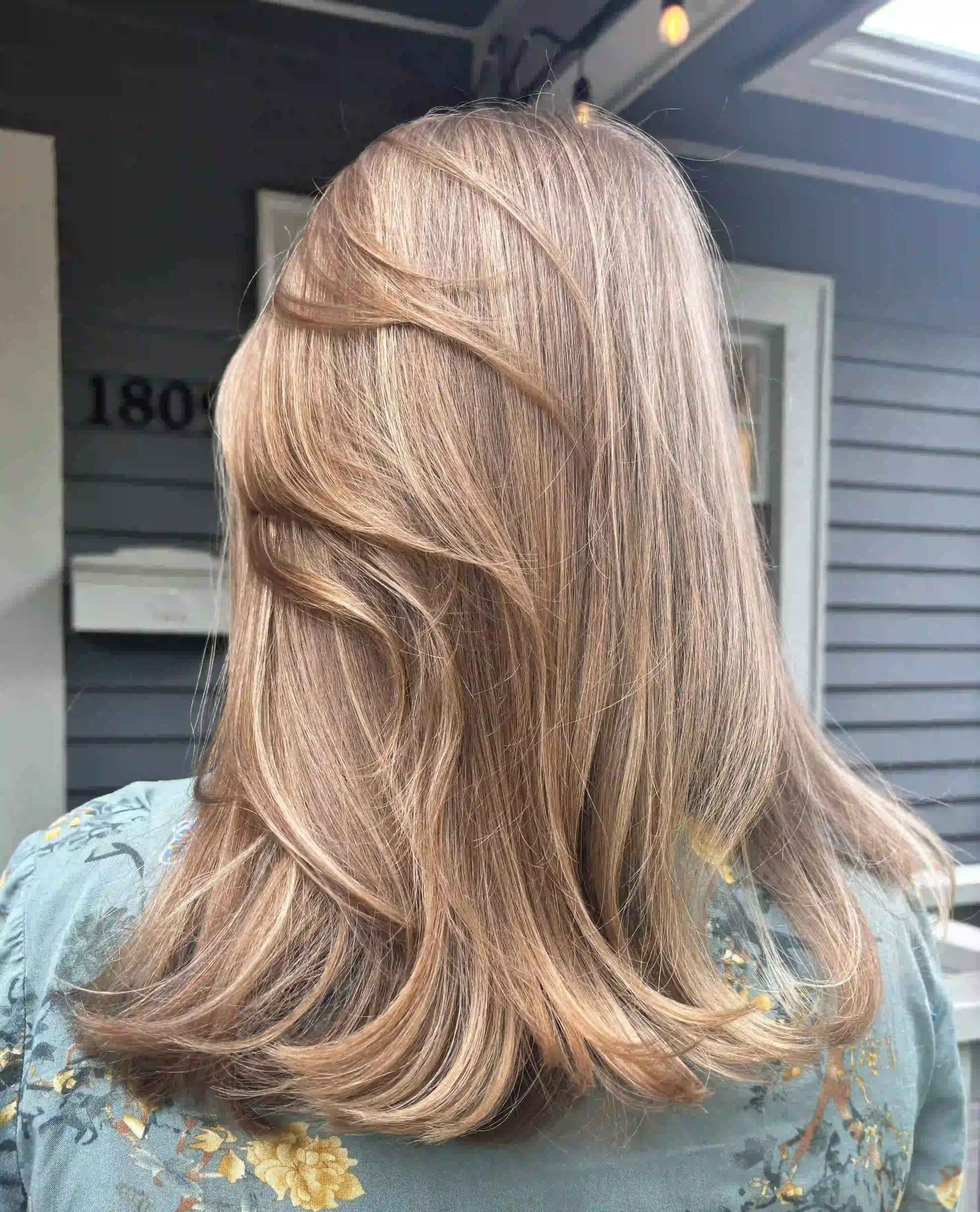 Layered beige blonde hair with soft movement and a smooth, polished finish, created by Alpin at Chroma Salon Seattle for natural dimension and shine.