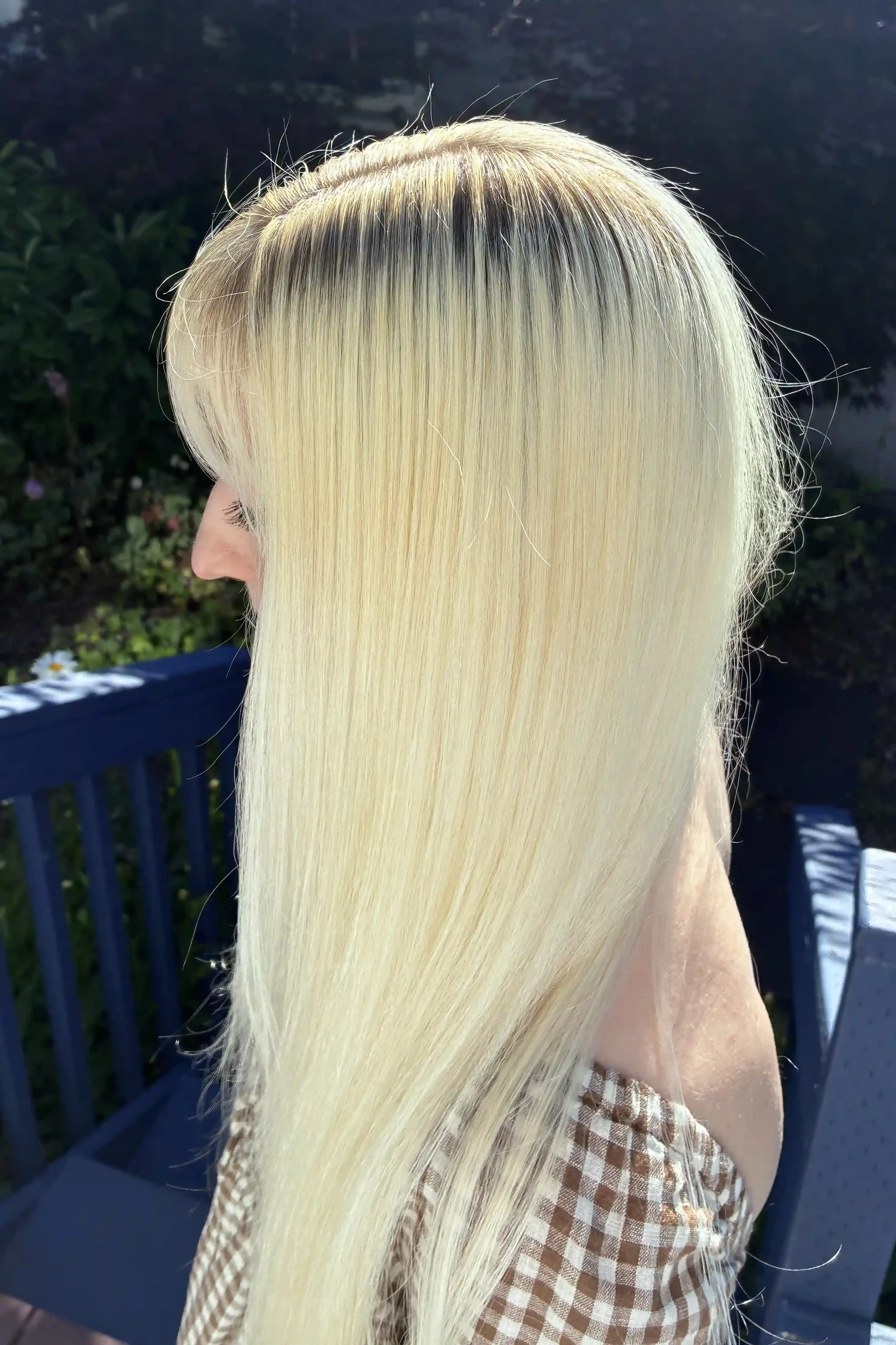 Bright platinum blonde hair with a soft root smudge for seamless grow-out, achieved through an all-over blonding service and finished with a silky, glass-like blowout. The ultra-light blonde has a clean, creamy tone with exceptional shine and a smoot