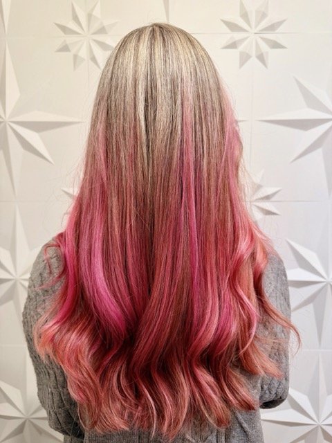 Blonde to vivid pink ombré hair with soft waves and long layers, created by Stormi at Chroma Salon Queen Anne Seattle for bold, dimensional color.