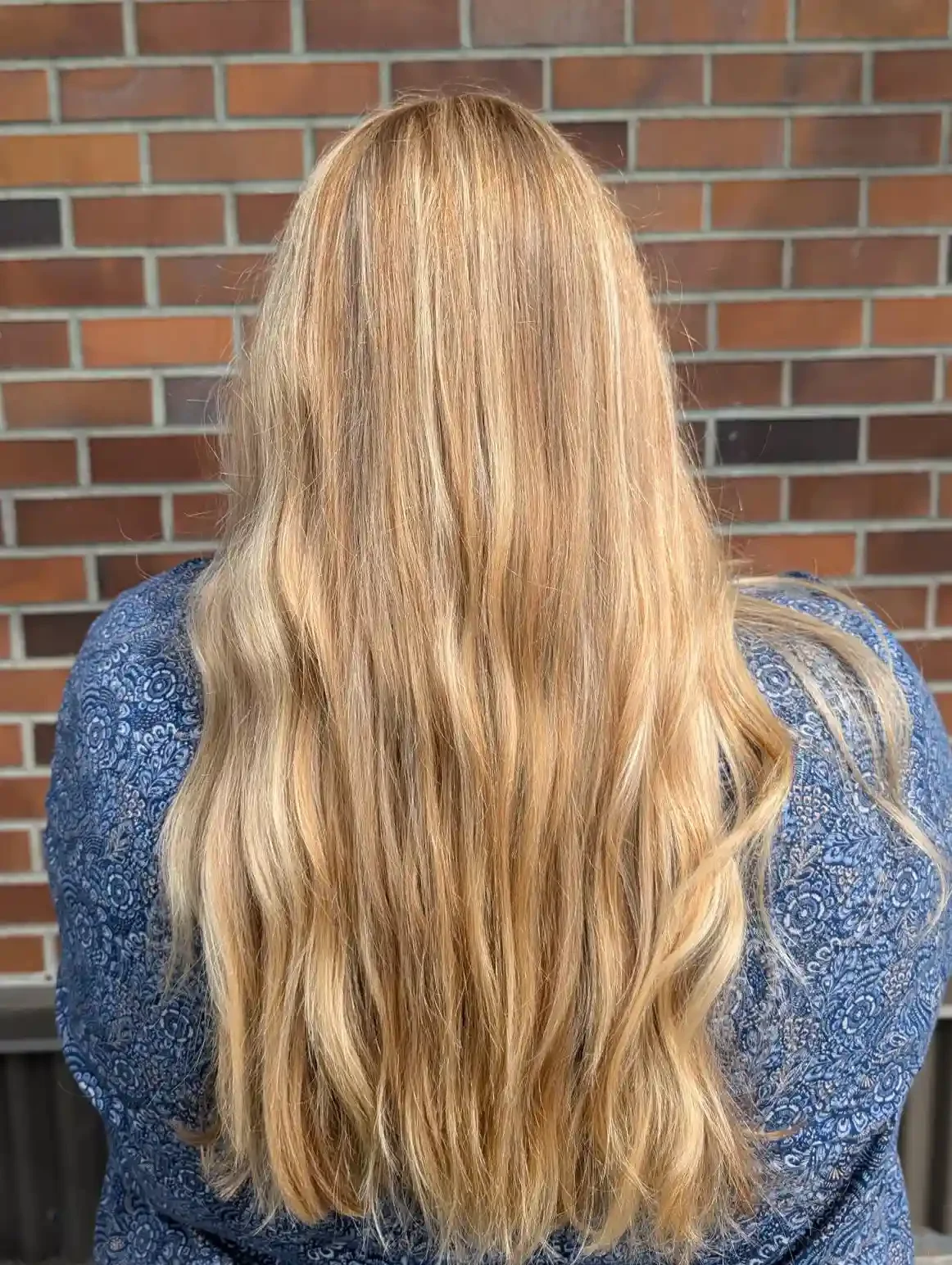 Golden beige blonde balayage with soft dimensional highlights and seamless blending from root to ends. Long flowing layers and loose waves create a bright, natural-looking blonde with glossy shine and lived-in softness.