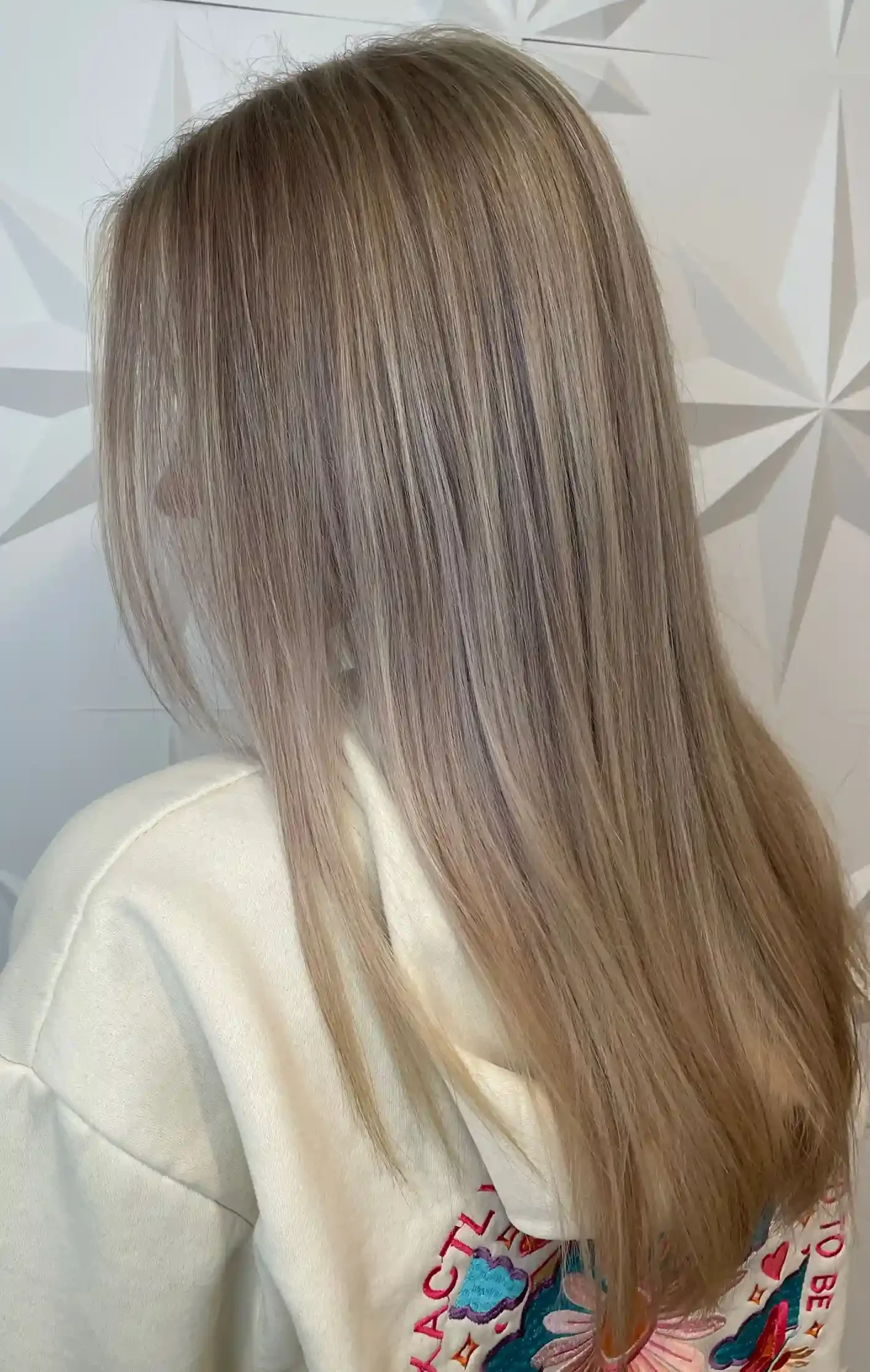 Dimensional icy beige blonde with finely woven highlights and lowlights for a soft, natural blend. A cool-toned root melt creates seamless depth and low-maintenance grow-out, while the smooth finish showcases shine, brightness, and refined dimension.
