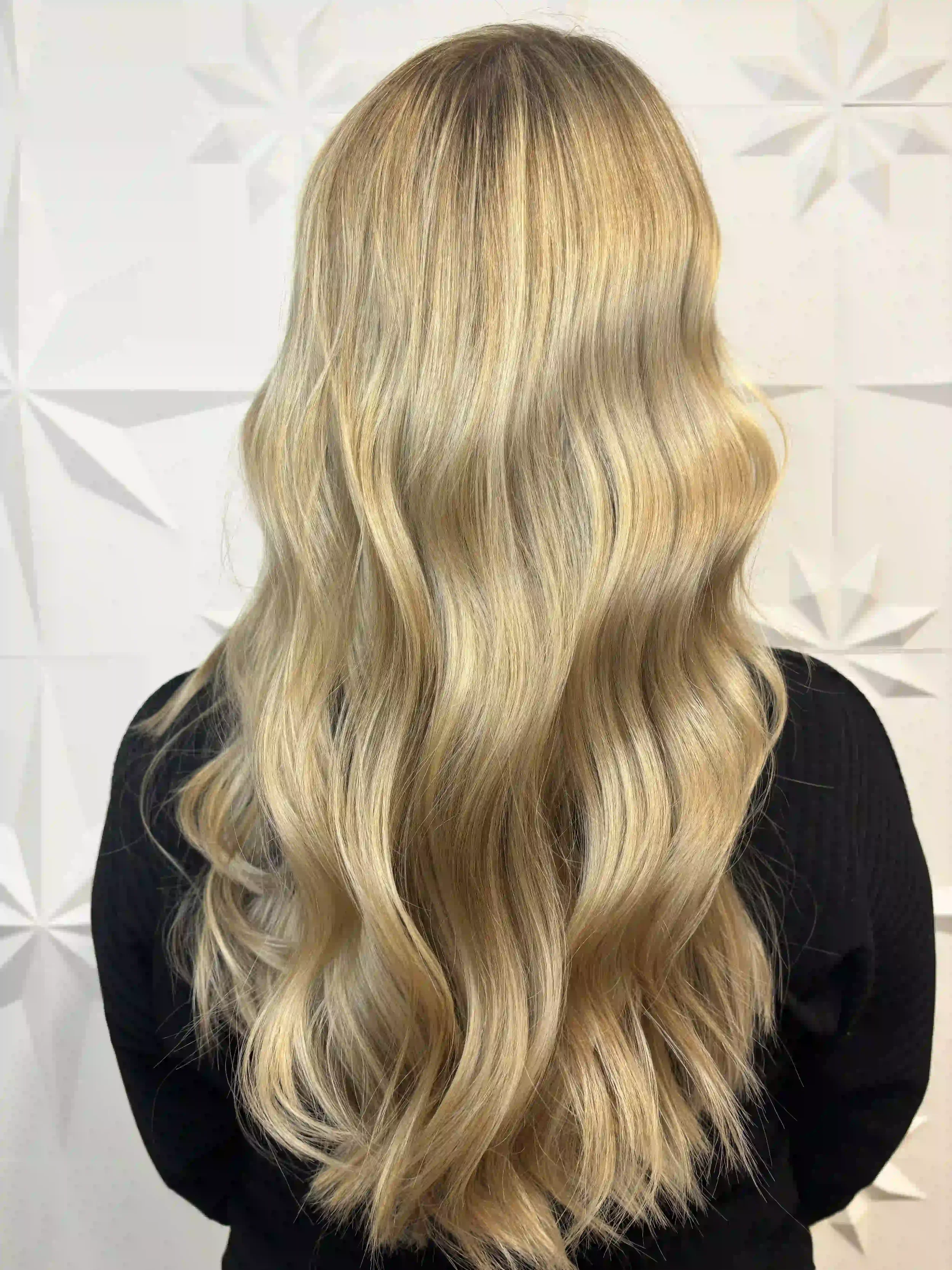 Soft golden blonde hair with long, flowing waves and dimensional color, created by Alpin at Chroma Salon Queen Anne Seattle for a bright, natural-looking finish.