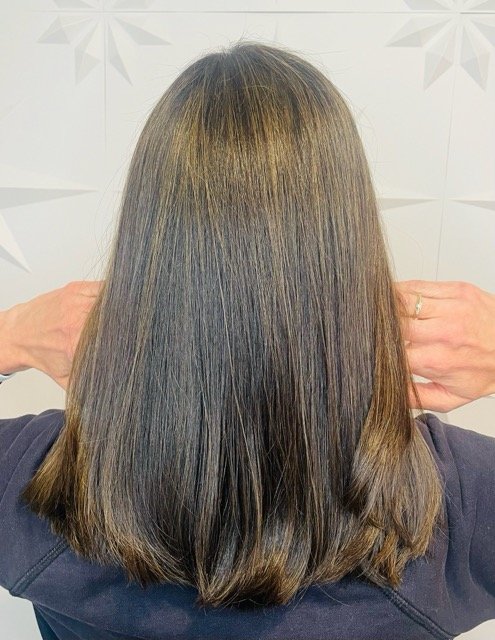 Dark brunette hair with subtle caramel highlights and a smooth, blunt cut, created at Chroma Salon Queen Anne for natural shine and dimension.