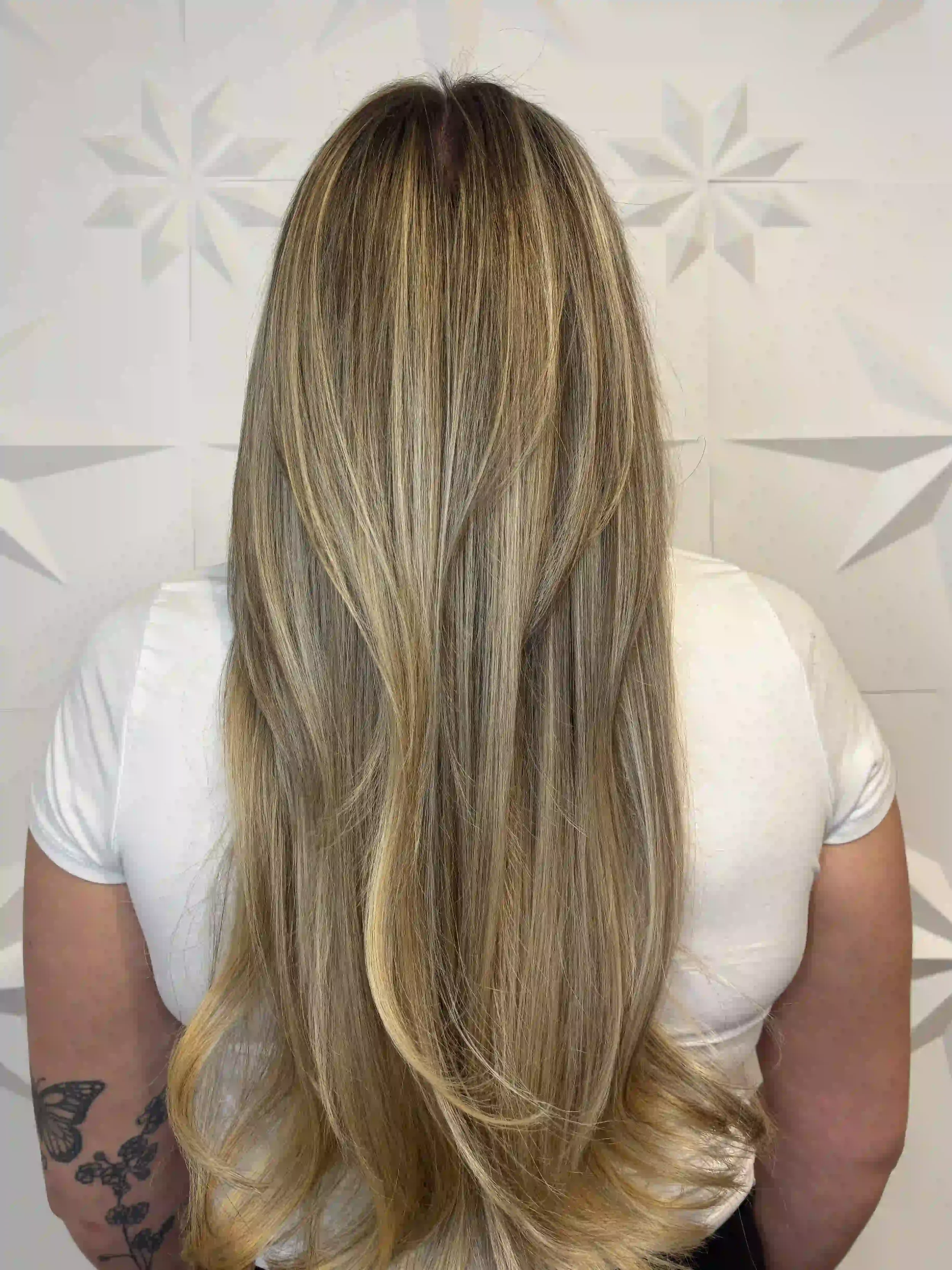 Long dimensional blonde balayage with soft layering and a smooth, polished finish, styled by Alpin at Chroma Salon Seattle.