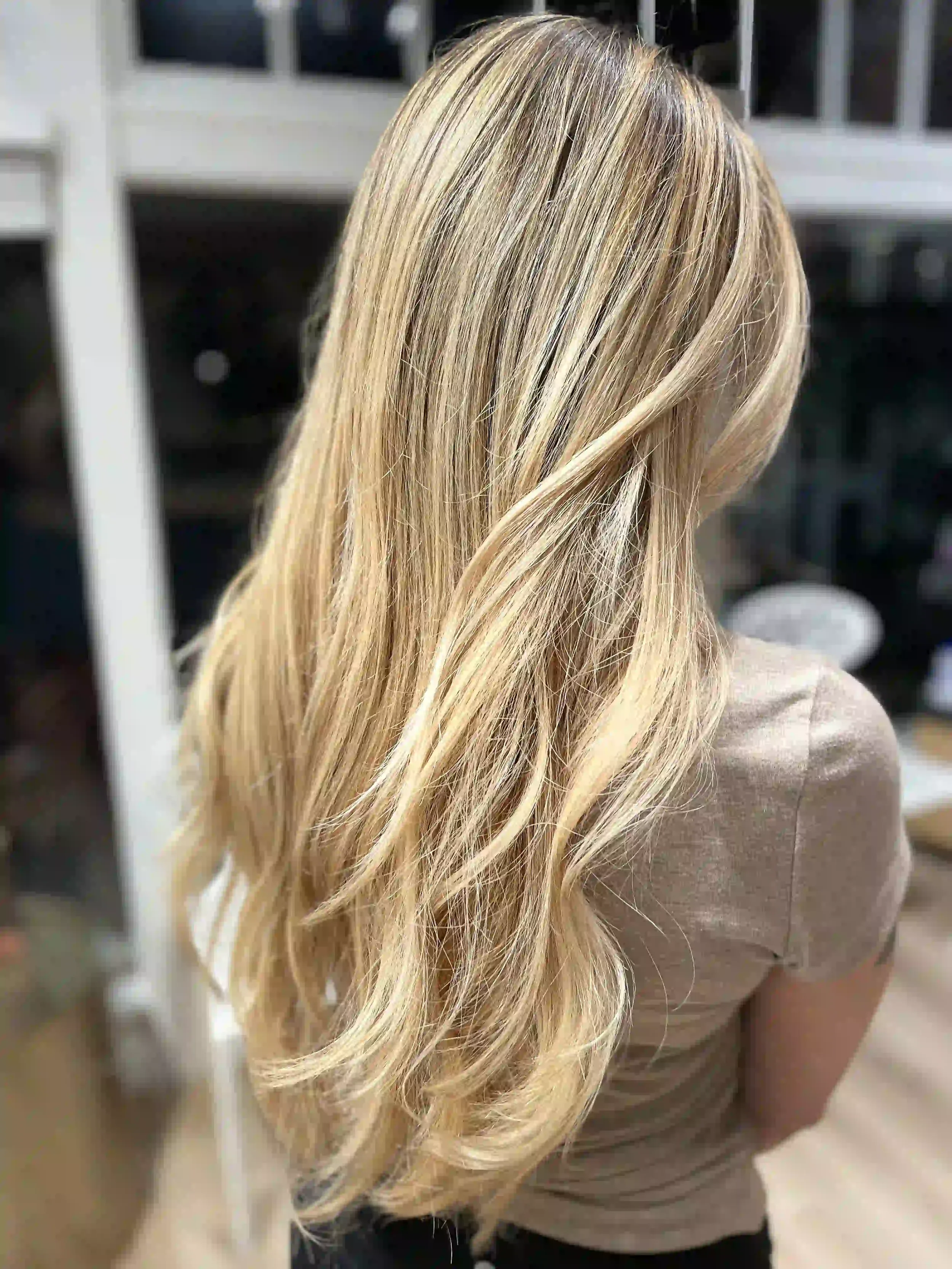 Bright dimensional blonde hair with long layers, soft face-framing highlights, and flowing texture, styled by Anna at Chroma Salon Wallingford Seattle.