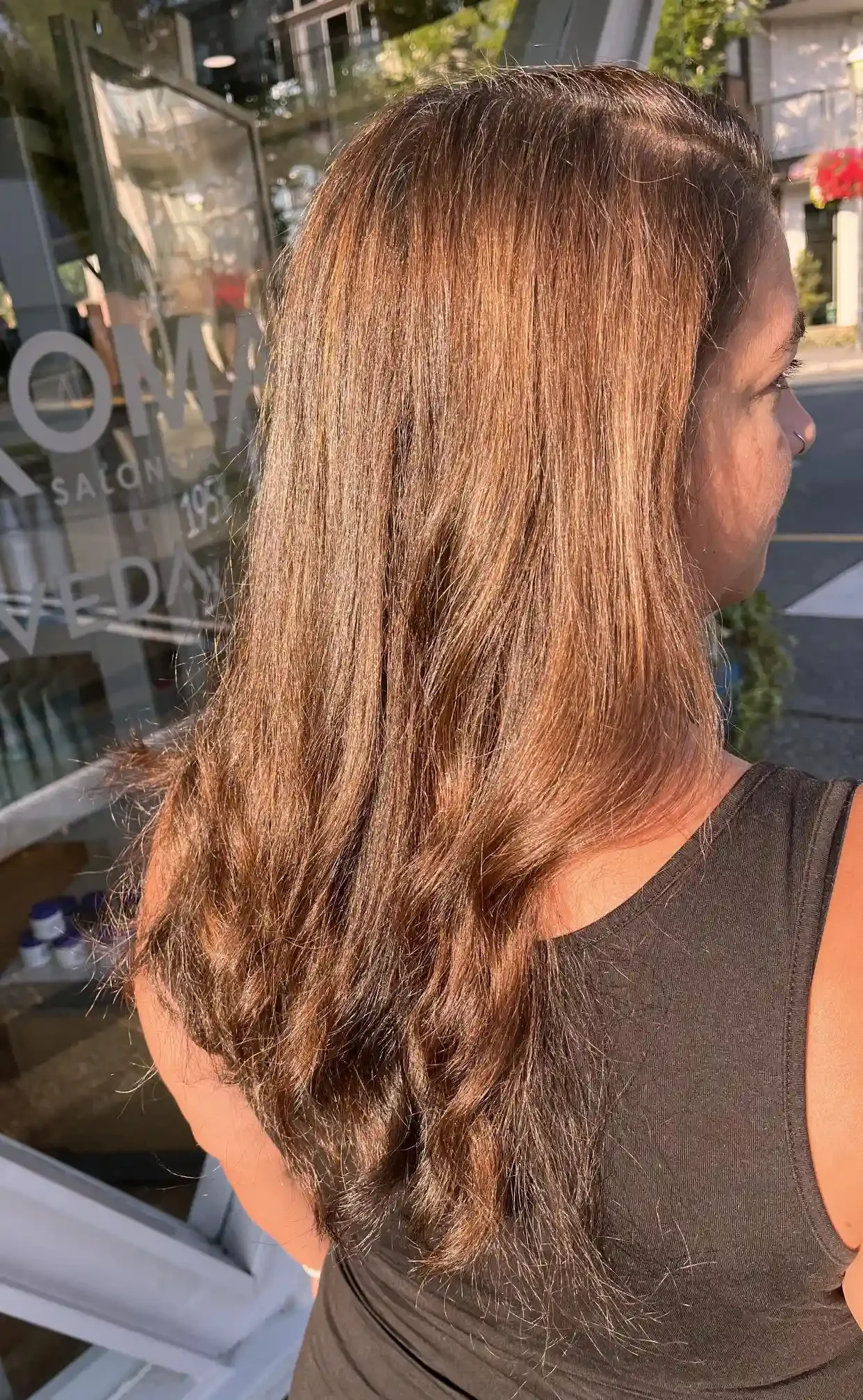Warm copper brunette balayage with soft dimensional highlights and glossy long layers. Subtle ribboning catches the light to create a rich, sunlit finish with natural movement and shine.