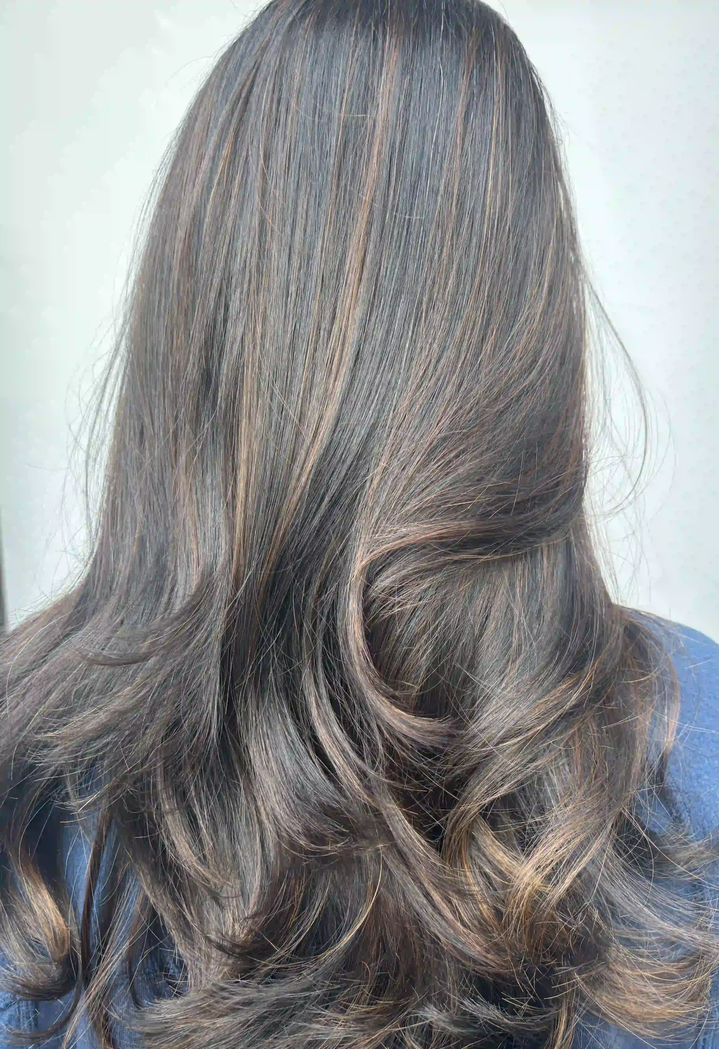 Dimensional brunette hair with subtle highlights and long, flowing layers, styled by Alpin at Chroma Salon Queen Anne Seattle for soft movement and natural depth.