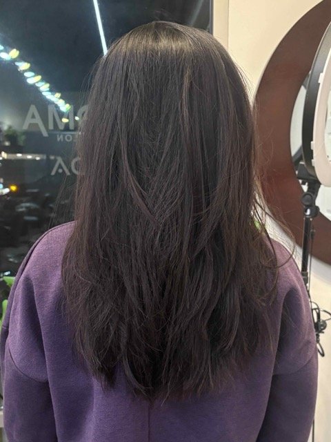 Long, layered dark brunette haircut with natural texture and soft movement, photographed after a professional cut and style at Chroma Salon in Lynnwood
