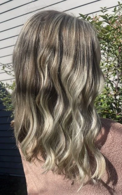 Dimensional blonde balayage with a seamlessly blended shadow root, bright face-framing ribbons, and cool beige blonde ends. Styled with soft waves to showcase depth, contrast, and a natural lived-in grow-out. Color and style by Sydney at Chroma Salon