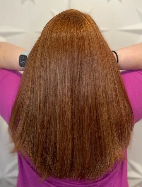 Rich copper red Aveda hair color with smooth, glossy finish and precise haircut, created at Chroma Salon Seattle for vibrant, healthy shine.