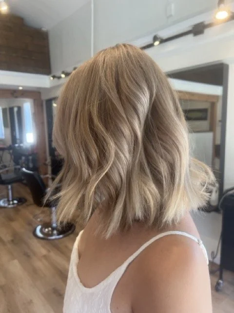 Soft blonde balayage long bob haircut with waves, styled at Chroma Salon Seattle. Professional stylists create modern, dimensional blonde looks for all hair types.