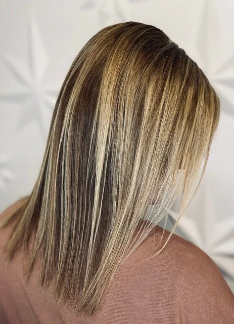 High-contrast blonde highlights with dimensional brunette lowlights and a sleek, straight finish, created at Chroma Salon Seattle using professional Aveda hair color.
