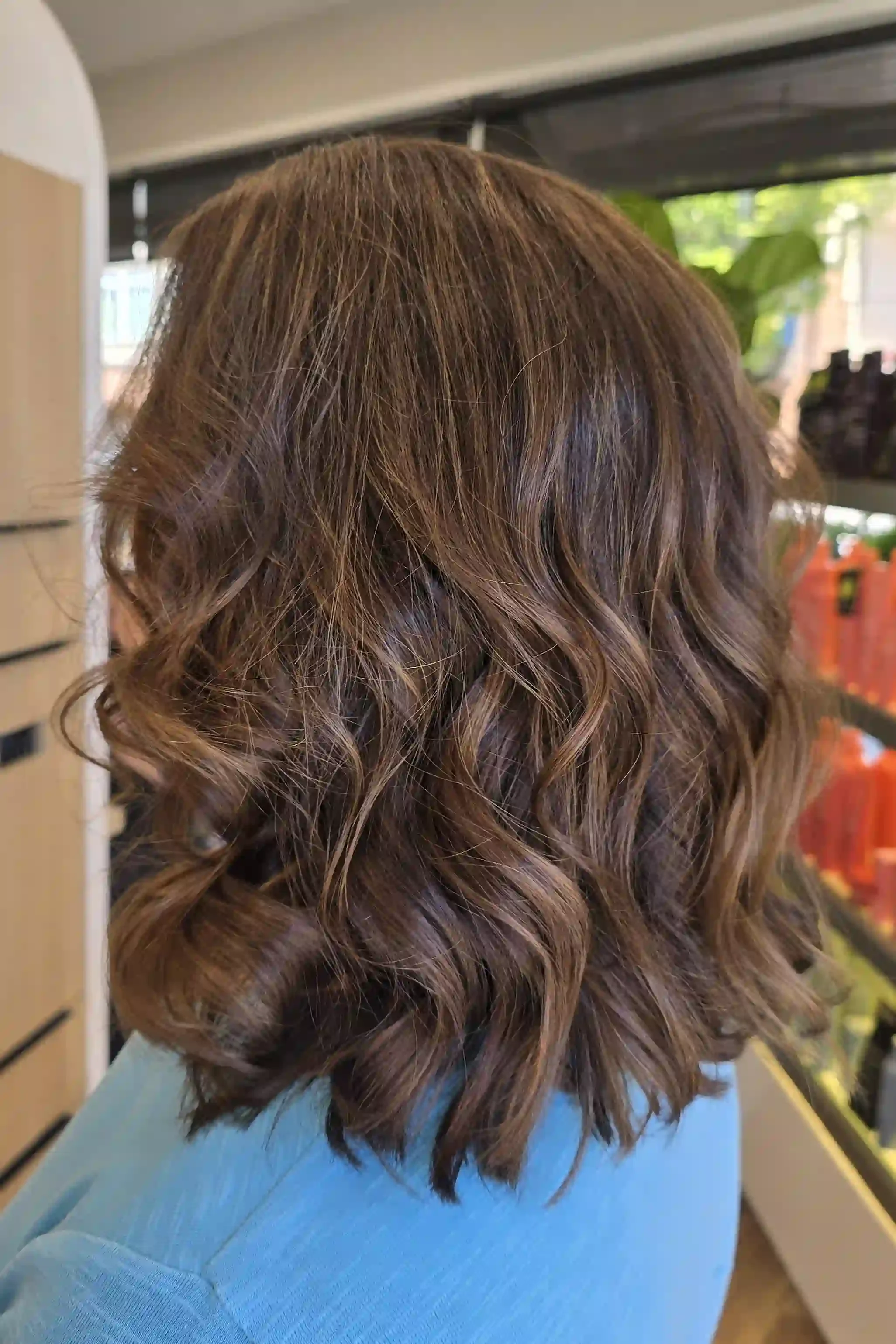 Brunette balayage lob with caramel dimension and soft polished waves, created by Jhana at Chroma Salon Edmonds.