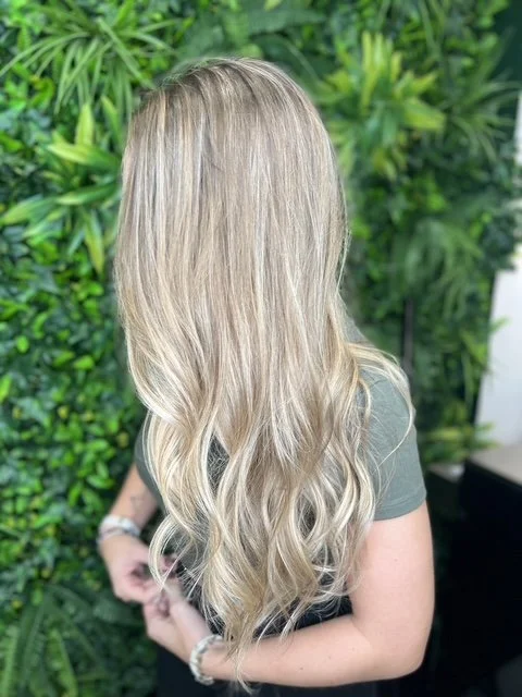Soft blonde balayage with long layers and natural waves, created at Chroma Salon Seattle for bright, dimensional blonding and a lived-in finish.