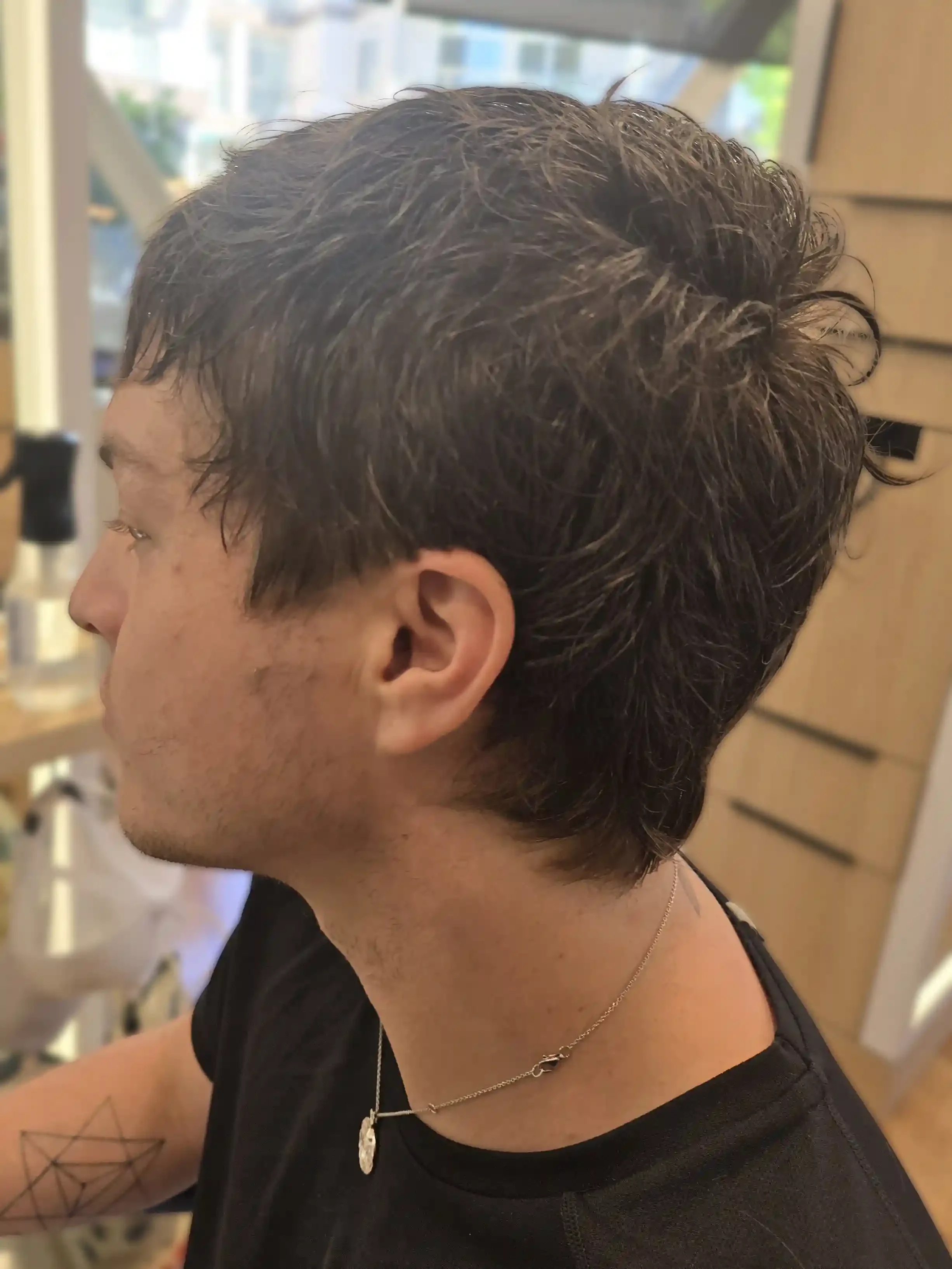 Medium-length men’s haircut featuring soft layering, natural texture, and a relaxed, effortless finish. The shape maintains length around the crown and nape while removing bulk for movement and versatility. Styled with a piecey, lived-in texture that