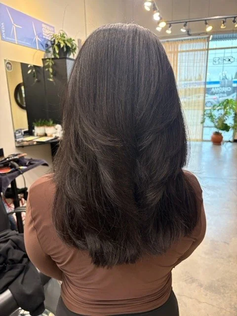 Long, layered dark brunette haircut with soft movement and a smooth, polished finish, styled at Chroma Salon Lynnwood.