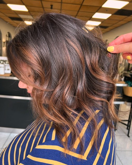Soft brunette balayage with warm caramel highlights and loose waves, created at Chroma Salon Seattle for natural dimension and shine.