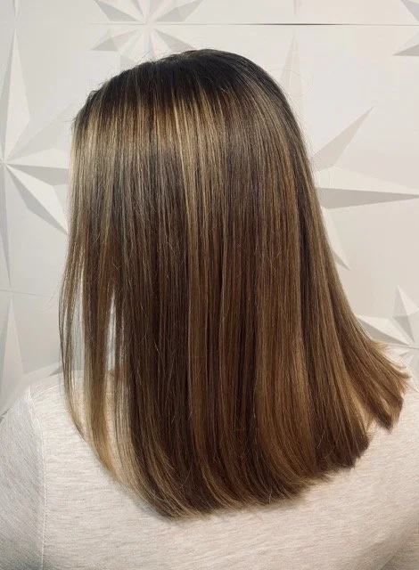 Dimensional brunette with soft blonde highlights and a sleek, straight finish, created at Chroma Salon Seattle using Aveda professional hair color.