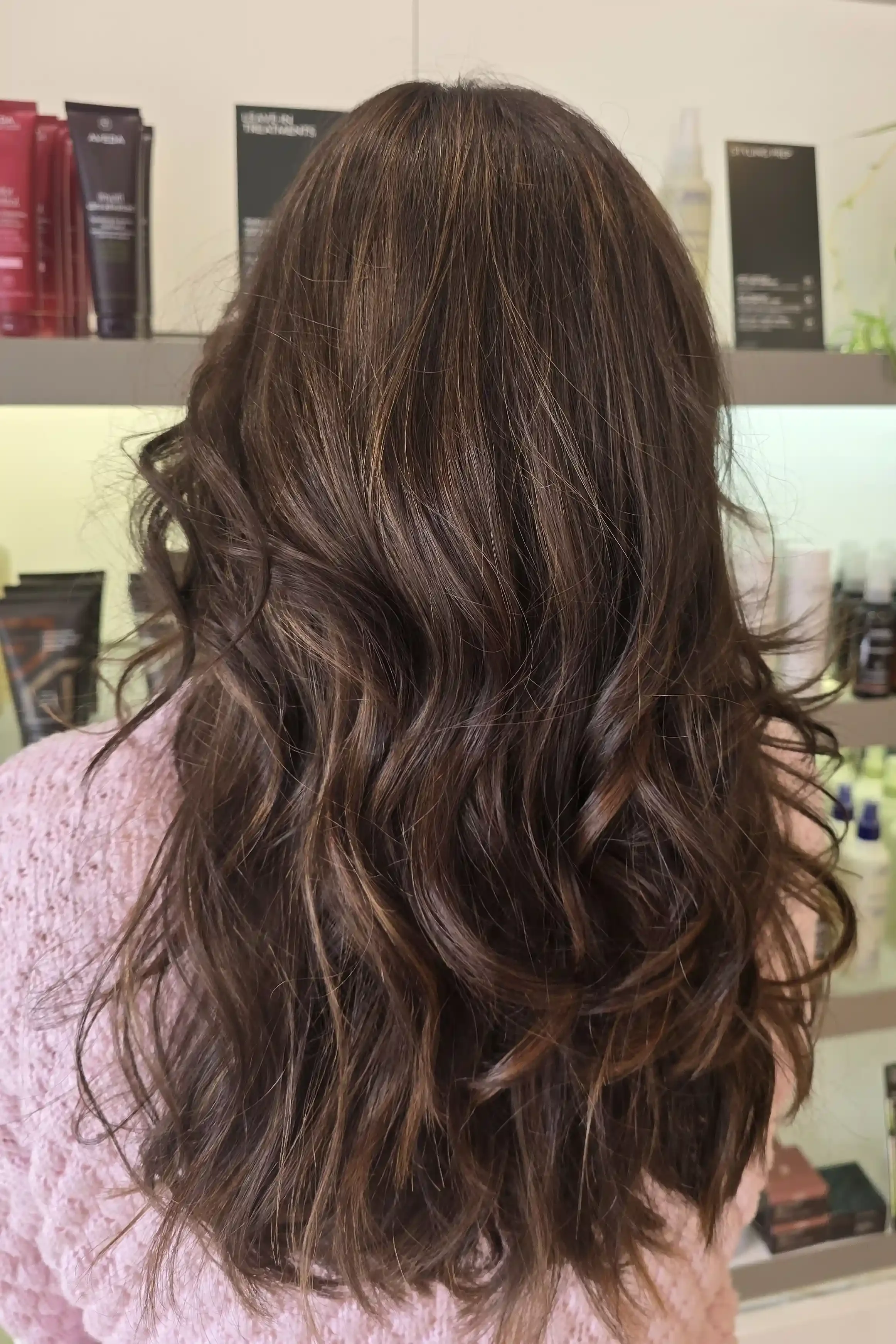 Rich espresso brunette balayage featuring subtle mocha and caramel dimension for a natural, multi-tonal finish. Styled with soft, flowing waves that enhance the depth, shine, and movement of the color while maintaining a lived-in, low-maintenance loo