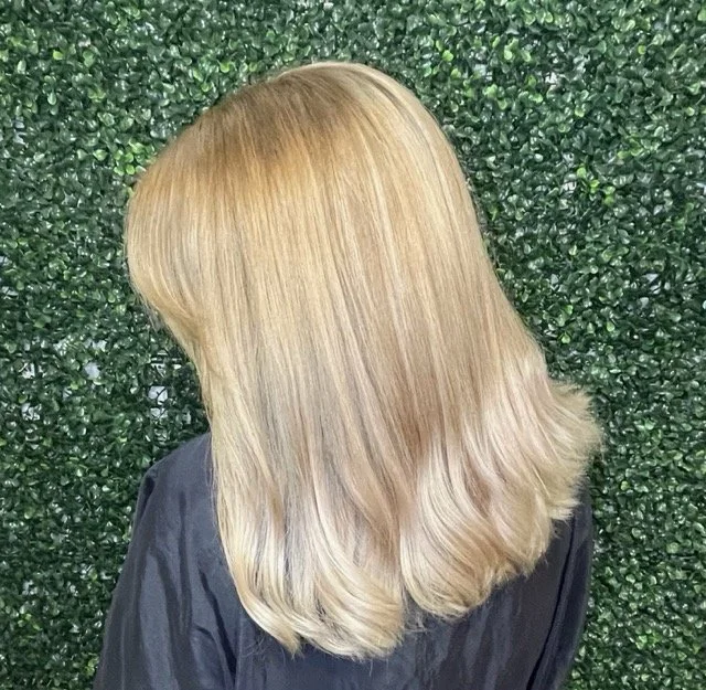 Soft neutral blonde Aveda hair color with smooth layers and glossy finish, created at Chroma Salon Seattle for healthy, dimensional shine.