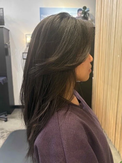 Long, layered brunette haircut with soft movement and face-framing layers, styled at Chroma Salon in Seattle for a natural, polished finish.