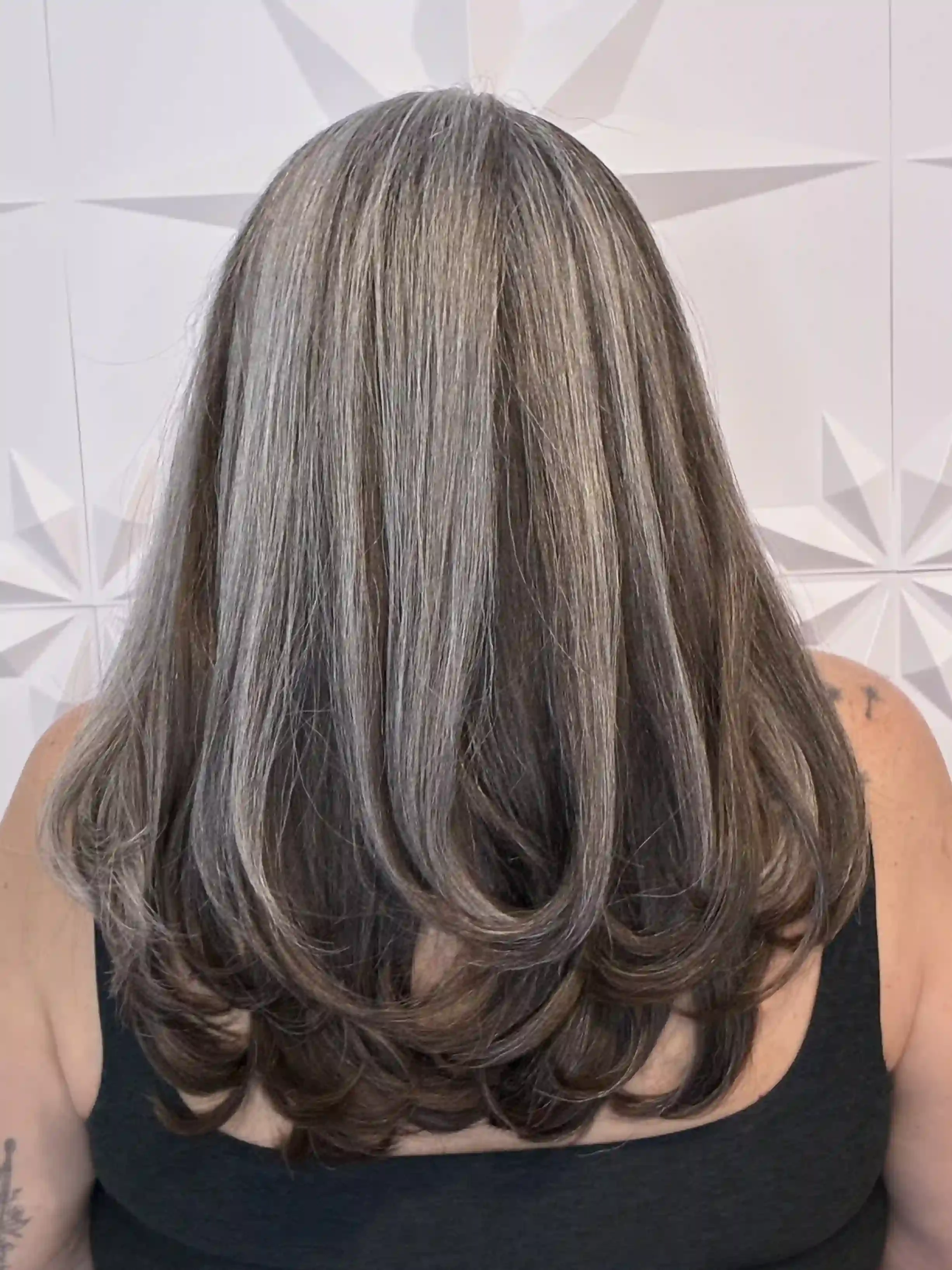 Expert grey blending with dimensional brunette lowlights and cool-toned highlights for a natural, seamless transition. This long layered haircut adds movement and softness while enhancing shine, depth, and contrast, creating a low-maintenance color r