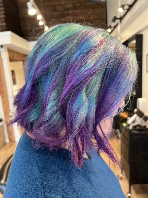 Vivid multicolor hair with teal, purple, and pastel tones in a textured bob, created at Chroma Salon Seattle by expert creative color specialists.