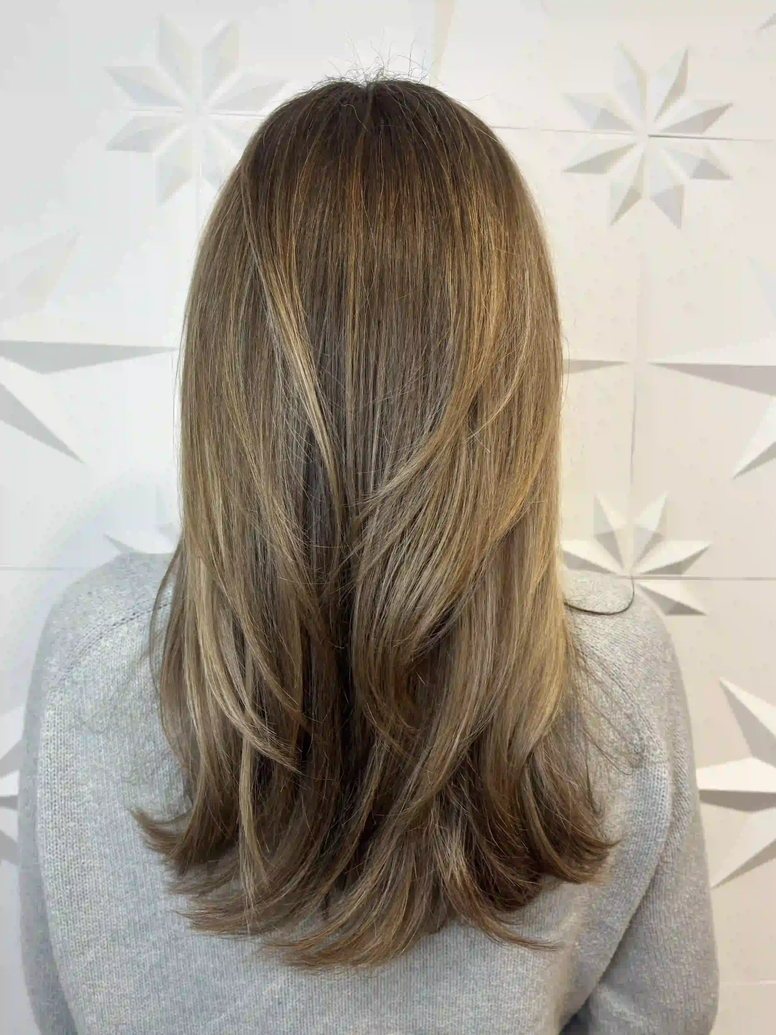 Long layered bronde hair with soft feathered ends and natural dimension, styled by Alpin at Chroma Salon Queen Anne Seattle for a light, effortless finish.