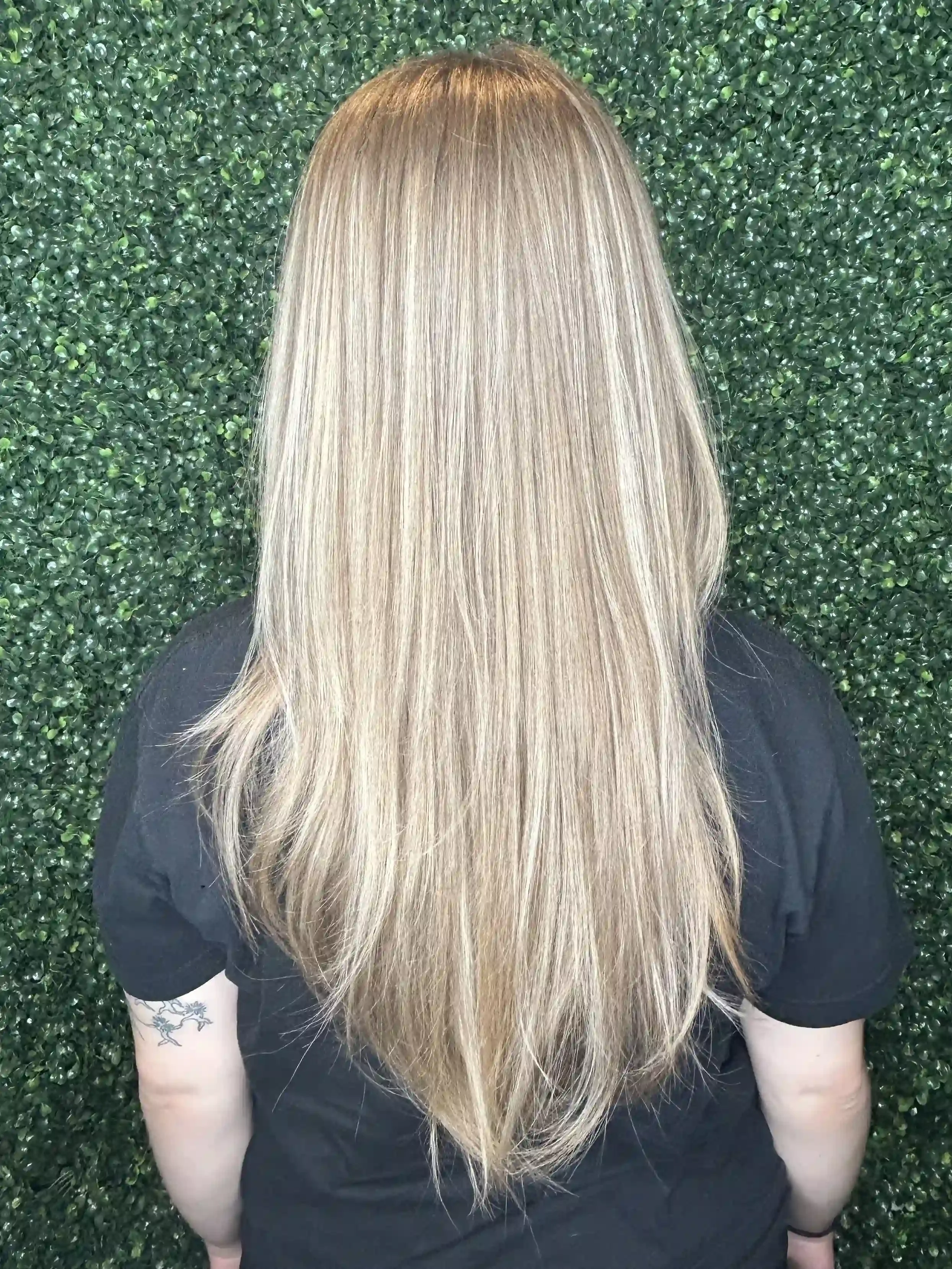 Cool beige blonde balayage with soft dimensional highlights and a seamless root blend for a natural, lived-in finish. This long layered haircut enhances movement and fullness while maintaining bright, healthy-looking blonde tones with low-maintenance