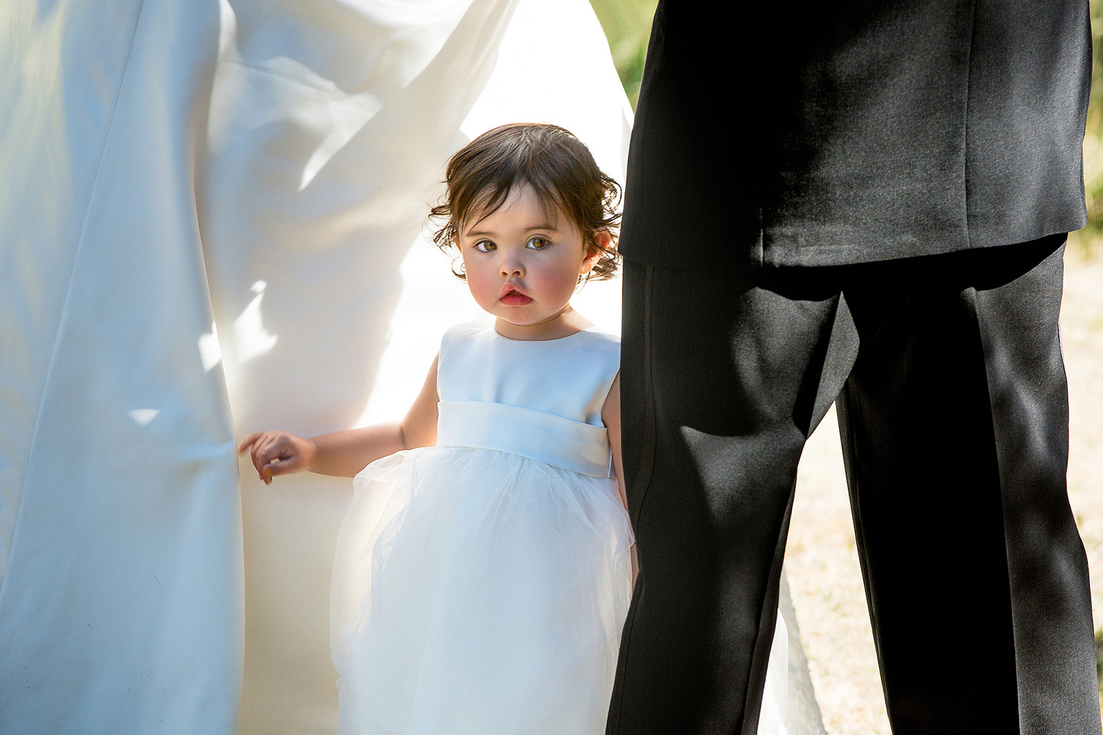 A little girl hides between his mother and father during their wedding service in Zortman, Montana.