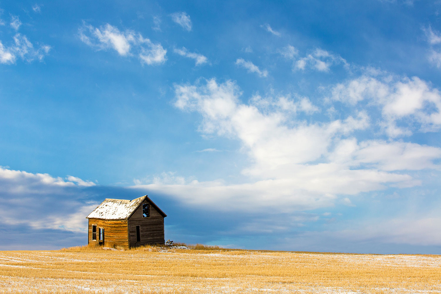 An old abandoned house surrounded by wheat stubble and snow south of Lake Elwell in Montana. → Buy This Print